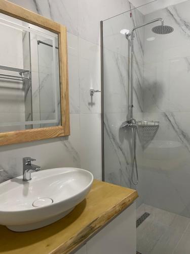 a white bathroom with a sink and a shower at Adria Hotel in Golem