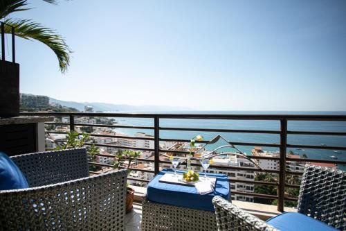 a table on a balcony with a view of the ocean at Pinnacle Resorts 180 in Puerto Vallarta
