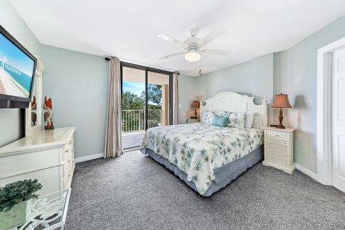a bedroom with a bed and a tv and a window at Compass Point 310 in Gulf Shores