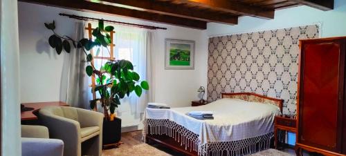 a bedroom with a bed and a chair and a plant at Casa Vasu 