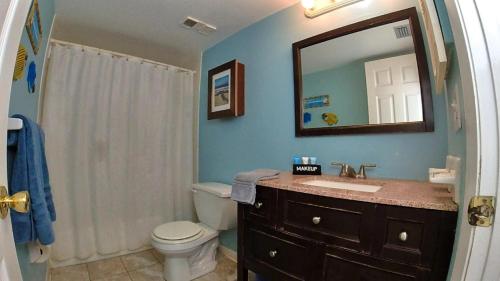 La salle de bains est pourvue d'un lavabo, de toilettes et d'un miroir. dans l'établissement Sea Club Condo #12, à Clearwater Beach