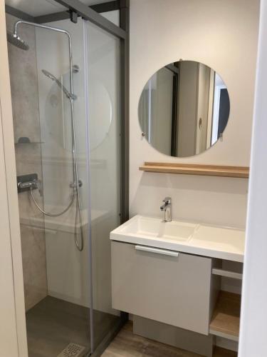 a bathroom with a shower and a sink and a mirror at Cottage 2 pers KEY WEST Premium in Hourtin
