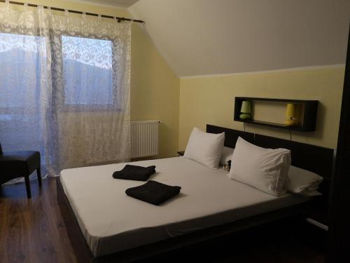 1 dormitorio con 1 cama con 2 toallas en Lake House Magnolia, en Buhalniţa