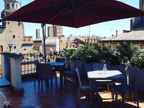a patio with tables and chairs and an umbrella at Hotel Roma in Bologna