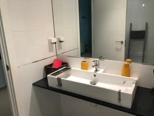 bagno con lavandino bianco e specchio di APARTAMENTO PRIVADO CERCA DE IFEMA y AEROPUERTO a Madrid