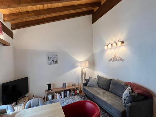a living room with a couch and a tv at Saas-Fee renovated flat in center of the village in Saas-Fee
