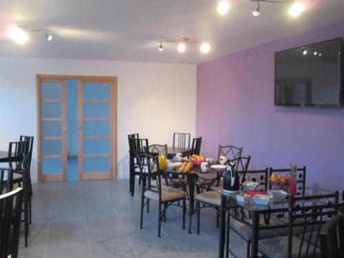 a dining room with a table and chairs and a tv at La Ferme de la Petite Noé in Tracy-sur-Mer