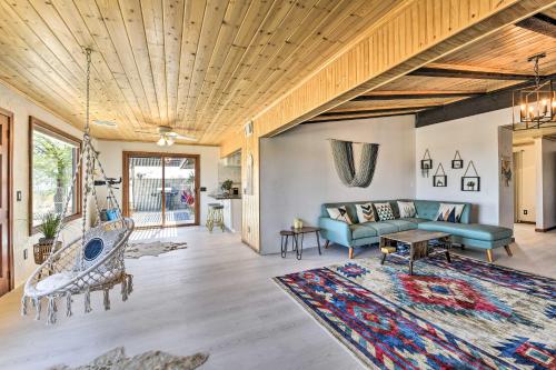 a living room with a blue couch and a rug at Chic Joshua Tree Pad with Mountain Views and Hot Tub in Twentynine Palms