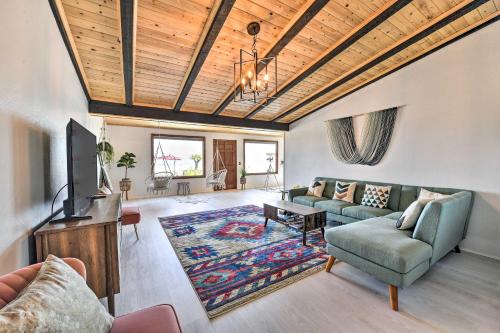 a living room with a couch and a tv at Chic Joshua Tree Pad with Mountain Views and Hot Tub in Twentynine Palms