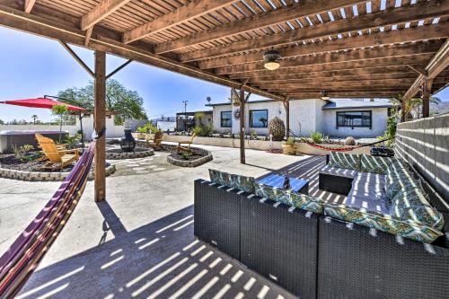 an outdoor patio with a wooden pergola at Chic Joshua Tree Pad with Mountain Views and Hot Tub in Twentynine Palms