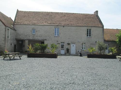 - un bâtiment avec une table de pique-nique devant dans l'établissement La Ferme de la Petite Noé, à Tracy-sur-Mer