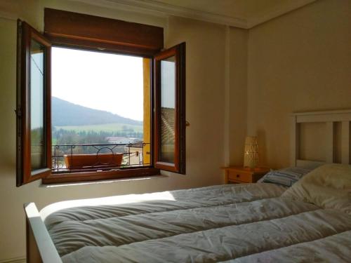 a bedroom with two beds and a window with a view at Casa Rural 643km in Villatuerta