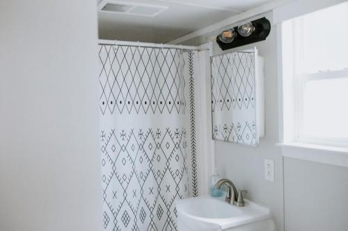 a bathroom with a shower curtain and a sink at Nest - Texas Tiny House with a Big View in Spring Branch