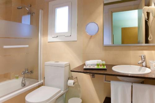 a bathroom with a toilet and a sink and a mirror at Senator Barcelona Apartments in Barcelona