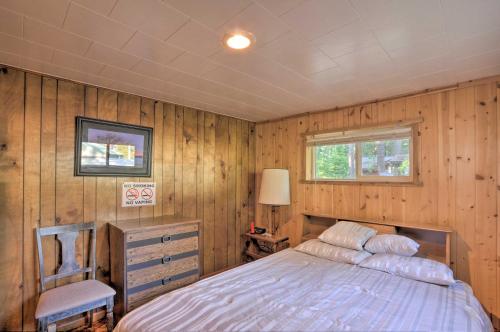 クラマスフォールズにあるCozy Klamath Falls Home Near Fishing and Parks!の木製の壁のベッドルーム1室、ベッド1台が備わります。