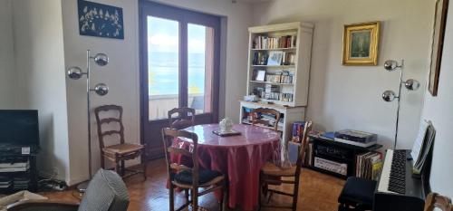 ein Esszimmer mit einem Tisch, Stühlen und einem Fenster in der Unterkunft Le Bellevue 2 in Thonon-les-Bains