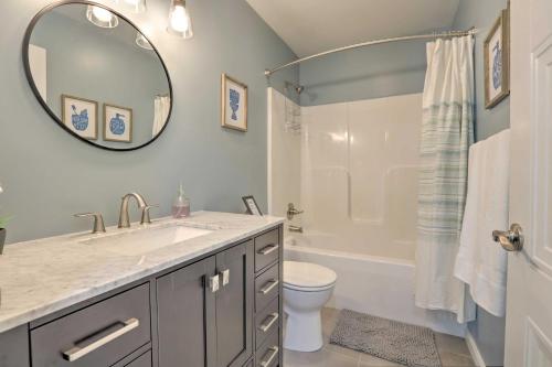 a bathroom with a sink and a toilet and a mirror at Rough River Lake House with Dual Primary Suites! in Fentress McMahan