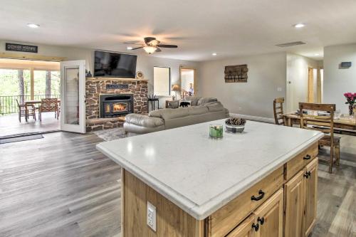 a kitchen and living room with a couch and a fireplace at Game Room and Wooded Views Pinetop Cabin! in Pinetop-Lakeside