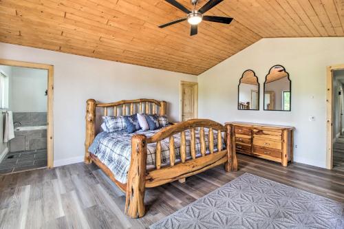 a bedroom with a wooden bed and a ceiling fan at Game Room and Wooded Views Pinetop Cabin! in Pinetop-Lakeside