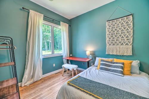 a bedroom with blue walls and a bed and a desk at Cozy Whitehall Hideaway with Hot Tub and Chiminea! in Whitehall