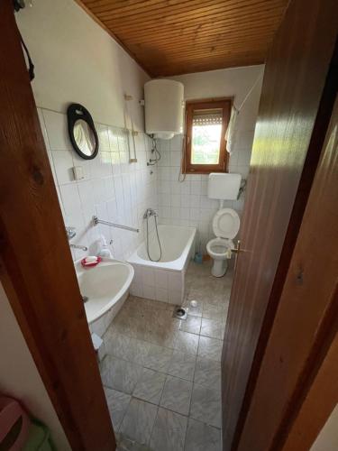 een badkamer met een bad, een wastafel en een toilet bij Vikendica na selu, blizu BG 