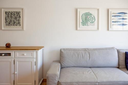 a couch in a living room with two pictures on the wall at Monte Gordo Beach Flat with Balcony in Monte Gordo
