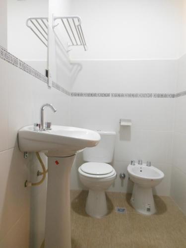 a white bathroom with a sink and a toilet at Parque Hotel in San Salvador de Jujuy