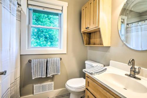 a bathroom with a toilet and a sink and a window at Waterfront Mound Retreat with Dock and Lake Access! in Mound