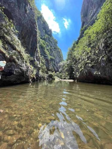a person in a boat in a river in a canyon at Odmaralište Vlaško ždrelo in Pirot