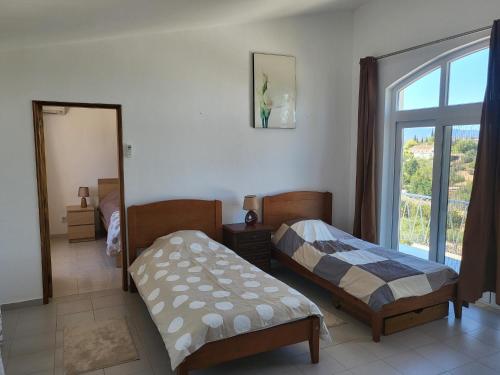 a bedroom with two beds and a window at Villa Madeira in Silves