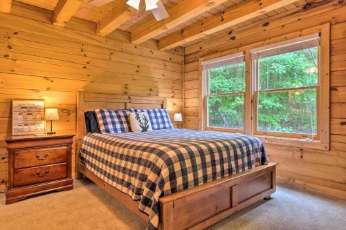 a bedroom with a bed in a log cabin at Moonshine Manor Cabin with Fire Pit and Hot Tub! in Lake Lure