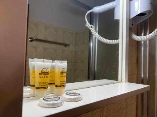 a bathroom counter with two cups and a mirror at ERIDA Accommodation in Lákka