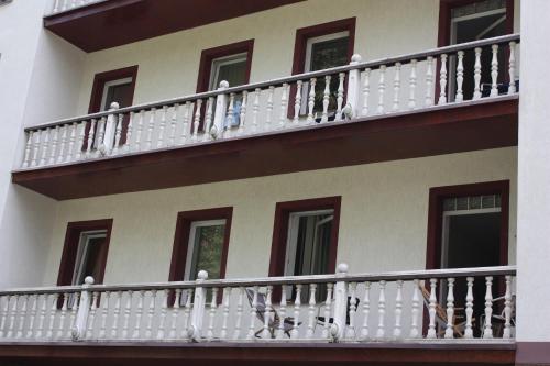 un edificio con balcones blancos y ventanas marrones en Willa Maxim, en Lądek-Zdrój