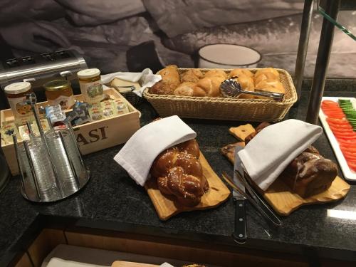 a table with bread and a basket of pastries at Hotel Piz Buin in Ischgl