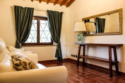 a living room with a mirror and a couch at Tenuta Tegolato in Barberino di Val dʼElsa