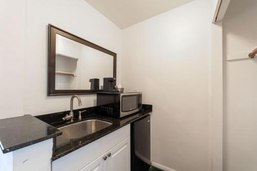 a bathroom with a sink and a microwave at Captain's Table Hotel by Everglades Adventures in Everglades City