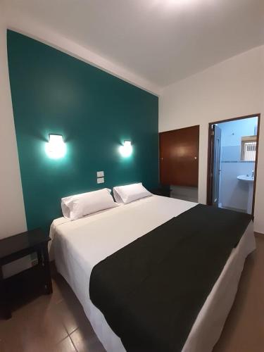 a bedroom with a large bed with a green wall at Parque Hotel in San Salvador de Jujuy