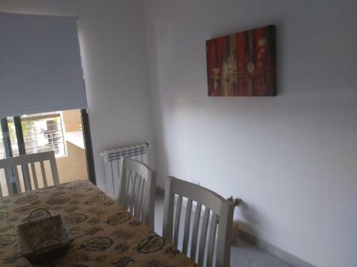 a dining room table and chairs with a painting on the wall at S4 Hermoso departamento para conocer Mendoza in Godoy Cruz