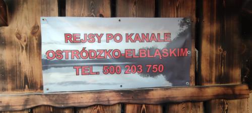 una señal en el lateral de una pared de madera en LisieBagno, en Miłomłyn