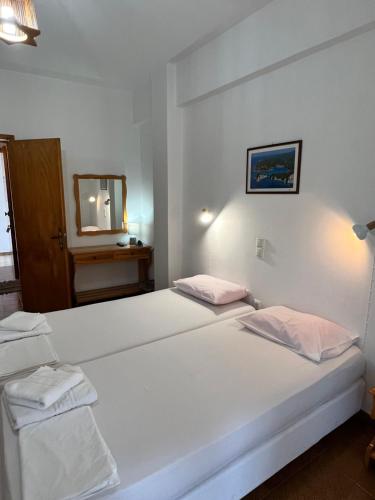 two beds in a room with a mirror at ERIDA Accommodation in Lákka