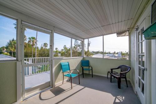 a screened porch with two chairs and windows at Captain's Table Hotel by Everglades Adventures in Everglades City