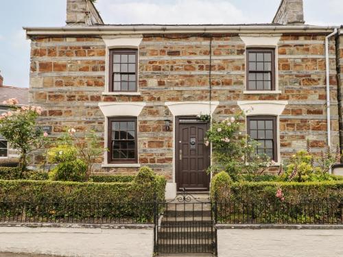an old brick house with a black door at Penywhelp House in Cardigan