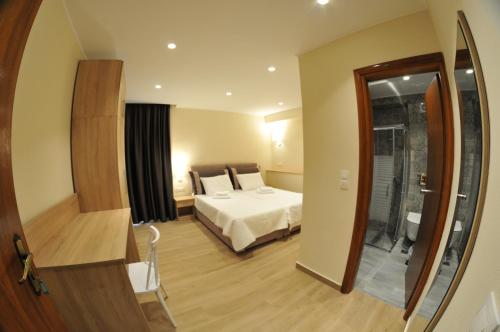 a hotel room with a bed and a mirror at Η ΦΛΩΚΑΤΗ in Spercheiada