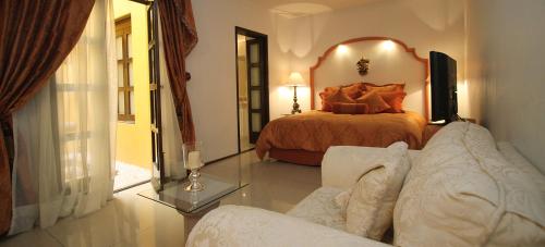 a living room with a bed and a couch at Palacio Borghese Hotel Boutique - Adults Only in Oaxaca City