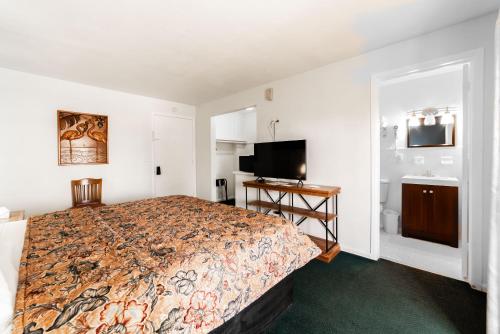 a bedroom with a bed and a flat screen tv at Captain's Table Hotel by Everglades Adventures in Everglades City