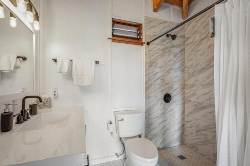 uma casa de banho branca com um WC e um chuveiro em Saltwater Hale em Princeville