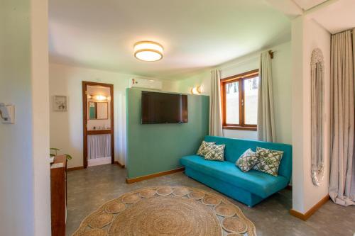 a living room with a blue couch and a flat screen tv at Pousada Recanto do Arraial in Arraial d'Ajuda