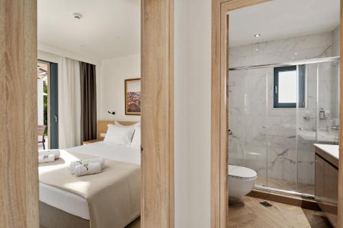 ein Schlafzimmer mit einem Bett, einer Dusche und einem WC in der Unterkunft Perithia Suites in Perítheia