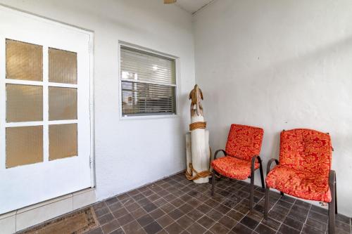 two red chairs in a room with a window at Captain's Table Hotel by Everglades Adventures in Everglades City