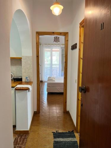 a hallway with a room with a bed and a door at ERIDA Accommodation in Lákka